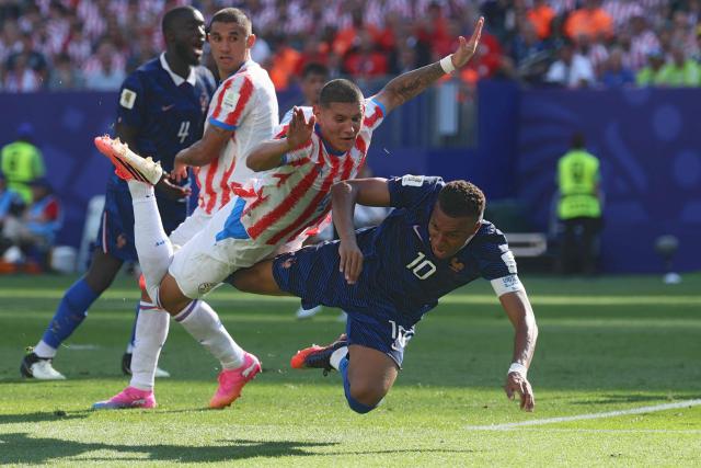 Paraguay's defender #04 Juan Jose Caceres and France's forward #10 Kylian Mbappe fall on the ground during the 2026 World Cup round of 16 football match between Paraguay and France at the Philadelphia Stadium in Philadelphia on July 4, 2026.  (Photo by Odd ANDERSEN / AFP)