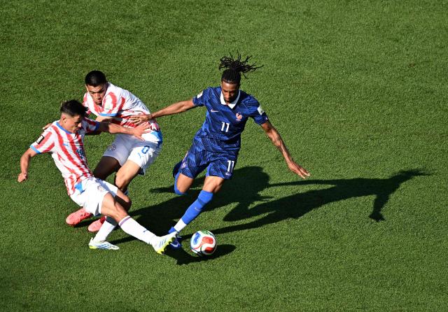 France's forward #11 Michael Olise, Paraguay's midfielders #14 Andres Cubas and #08 Diego Gomez fight for the ball during the 2026 World Cup round of 16 football match between Paraguay and France at the Philadelphia Stadium in Philadelphia on July 4, 2026.  (Photo by Jewel SAMAD / AFP)