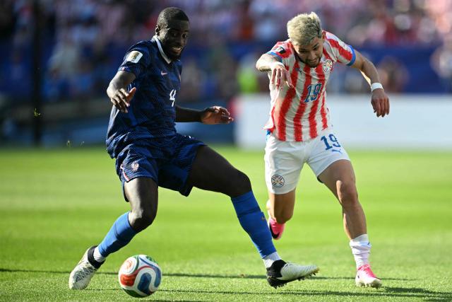 France's defender #04 Dayot Upamecano and Paraguay's midfielder #19 Julio Enciso fight for the ball during the 2026 World Cup round of 16 football match between Paraguay and France at the Philadelphia Stadium in Philadelphia on July 4, 2026.  (Photo by MAURO PIMENTEL / AFP)