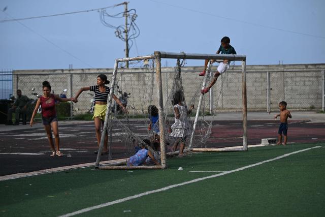 Children play at the Jose Maria Vargas sports complex in Maiquetia, La Guaira state, Venezuela, on July 3, 2026, following the June 24 twin earthquakes. The death toll from Venezuela's devastating twin earthquakes has risen to 2,954, according to official figures released on Saturday. (Photo by Raul ARBOLEDA / AFP)