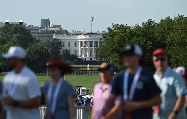 The White House is seen in the background as attendees make their way to attend tonight's "Salute to America" Independence Day celebration on the National Mall in Washington, DC, on July 4, 2026. The nation is marking the 250th anniversary of the United States Declaration of Indpendence. (Photo by Alex WROBLEWSKI / AFP)