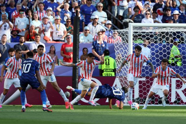 France's forward #20 Desire Doue is fouled by Paraguay's midfielder #14 Andres Cubas during the 2026 World Cup round of 16 football match between Paraguay and France at the Philadelphia Stadium in Philadelphia on July 4, 2026.  (Photo by Odd ANDERSEN / AFP)