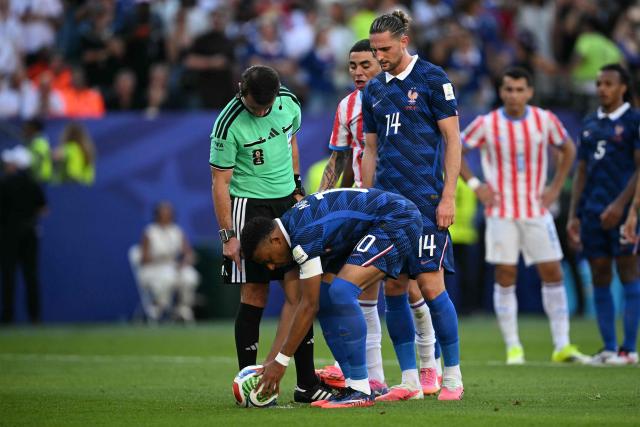 France's forward #10 Kylian Mbappe places the ball on the penalty spot past Uzbek referee Ilgiz Tantashev during the 2026 World Cup round of 16 football match between Paraguay and France at the Philadelphia Stadium in Philadelphia on July 4, 2026.  (Photo by MAURO PIMENTEL / AFP)