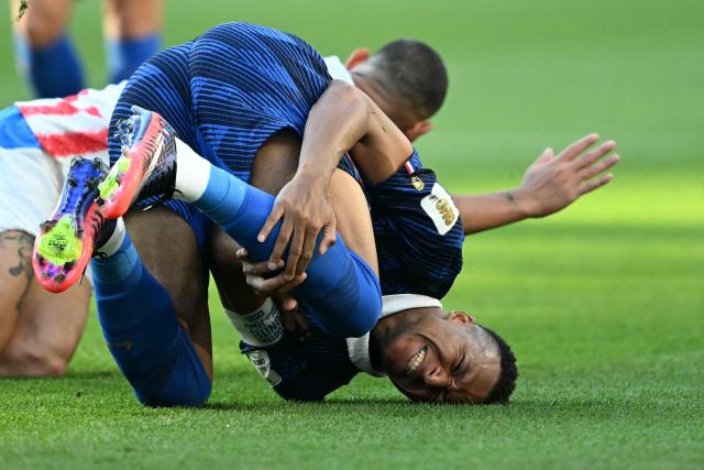 France's forward #10 Kylian Mbappe reacts on the ground past Paraguay's defender #04 Juan Jose Caceres during the 2026 World Cup round of 16 football match between Paraguay and France at the Philadelphia Stadium in Philadelphia on July 4, 2026.  (Photo by MAURO PIMENTEL / AFP)