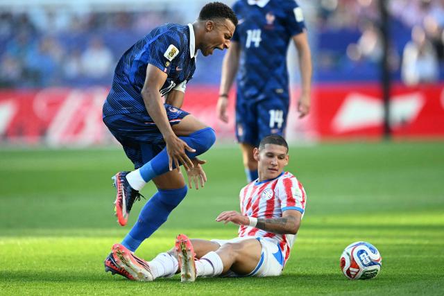 France's forward #10 Kylian Mbappe reacts past Paraguay's defender #04 Juan Jose Caceres during the 2026 World Cup round of 16 football match between Paraguay and France at the Philadelphia Stadium in Philadelphia on July 4, 2026.  (Photo by MAURO PIMENTEL / AFP)
