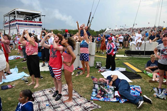People watch as US military jets perform a flyover during the "Salute to America" Independence Day celebration on the National Mall in Washington, DC, on July 4, 2026. The nation is marking the 250th anniversary of the United States Declaration of Indpendence. (Photo by Alex WROBLEWSKI / AFP)