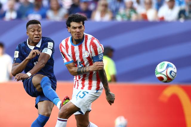 TOPSHOT - France's forward #10 Kylian Mbappe and Paraguay's defender #15 Gustavo Gomez fight for the ball during the 2026 World Cup round of 16 football match between Paraguay and France at the Philadelphia Stadium in Philadelphia on July 4, 2026.  (Photo by CHARLY TRIBALLEAU / AFP)