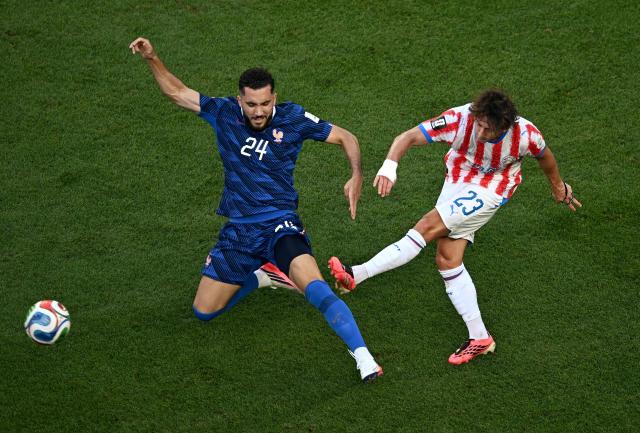 France's forward #24 Rayan Cherki and Paraguay's midfielder #23 Matias Galarza fight for the ball during the 2026 World Cup round of 16 football match between Paraguay and France at the Philadelphia Stadium in Philadelphia on July 4, 2026.  (Photo by Jewel SAMAD / AFP)
