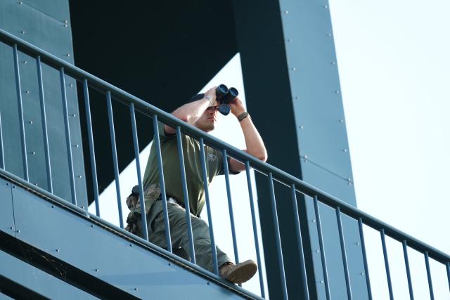 A security official is stationed in the Netherlands Carillon in Arlington, Virginia, across the river from Washington, DC, as people gather for the "Salute to America" Independence Day celebration on July 4, 2026. The nation is marking the 250th anniversary of the United States Declaration of Indpendence. (Photo by Ken Cedeno / AFP)