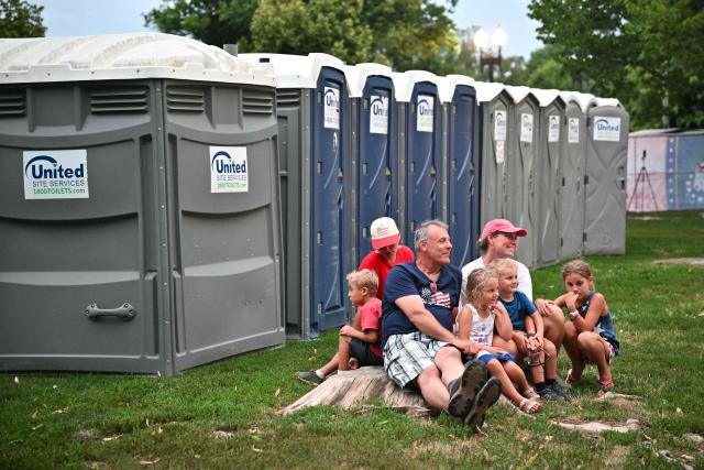 A family sits together after being evacuated from the event site due to thunderstorms in the area during the "Salute to America" Independence Day celebration on the National Mall in Washington, DC, on July 4, 2026. The nation is marking the 250th anniversary of the United States Declaration of Indpendence. (Photo by Mandel NGAN / AFP)