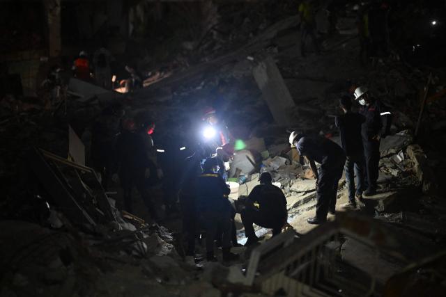 Rescuers and volunteers work amid the rubble of the OPPE buildings, a residential complex heavily damaged by the earthquakes, in Caraballeda, La Guaira state, Venezuela, on July 4, 2026. Venezuela's devastating twin earthquakes have killed nearly 3,000, official figures showed on July 4, as international rescue teams began winding down search operations for survivors in the rubble. (Photo by Juan BARRETO / AFP)