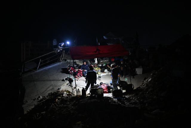 Rescuers and volunteers work amid the rubble of the OPPE buildings, a residential complex heavily damaged by the earthquakes, in Caraballeda, La Guaira state, Venezuela, on July 4, 2026. Venezuela's devastating twin earthquakes have killed nearly 3,000, official figures showed on July 4, as international rescue teams began winding down search operations for survivors in the rubble. (Photo by Juan BARRETO / AFP)