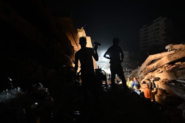 Rescuers and volunteers work amid the rubble of the OPPE buildings, a residential complex heavily damaged by the earthquakes, in Caraballeda, La Guaira state, Venezuela, on July 4, 2026. Venezuela's devastating twin earthquakes have killed nearly 3,000, official figures showed on July 4, as international rescue teams began winding down search operations for survivors in the rubble. (Photo by Juan BARRETO / AFP)