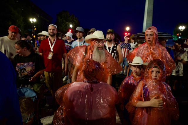 People wear ponchos after being evacuated from the event site of the "Salute to America" Independence Day celebration due to thunderstorms in the area in Washington, DC, on July 4, 2026. The nation is marking the 250th anniversary of the United States Declaration of Indpendence. (Photo by Amid FARAHI / AFP)