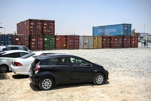 This photograph taken on June 18, 2026 shows cars parked at a container yard in the Spin Boldak district of Afghanistan's Kandahar province. In Afghanistan's southern Kandahar province, a once thriving business of trading car parts from far-flung places has crashed to a halt due to conflicts at the country's borders. (Photo by Sanaullah SEIAM / AFP)