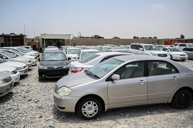 This photograph taken on June 18, 2026 shows cars parked at a container yard in the Spin Boldak district of Afghanistan's Kandahar province. In Afghanistan's southern Kandahar province, a once thriving business of trading car parts from far-flung places has crashed to a halt due to conflicts at the country's borders. (Photo by Sanaullah SEIAM / AFP)