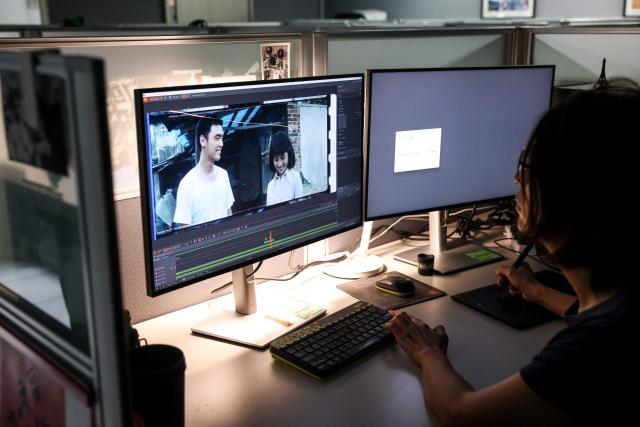 A technician performs digital restoration on a scanned film at the Taiwan Film and Audiovisual Institute in New Taipei City on June 23, 2026. In a dimly lit red-brick house in central Taiwan, film hunter Wang Wei and his team haul out ageing film reels, salvaging the fragile remnants of a cinema boom that nearly vanished from history. (Photo by I-Hwa Cheng / AFP) / TO GO WITH: Taiwan-culture-history-language, FEATURE by Joy CHIANG