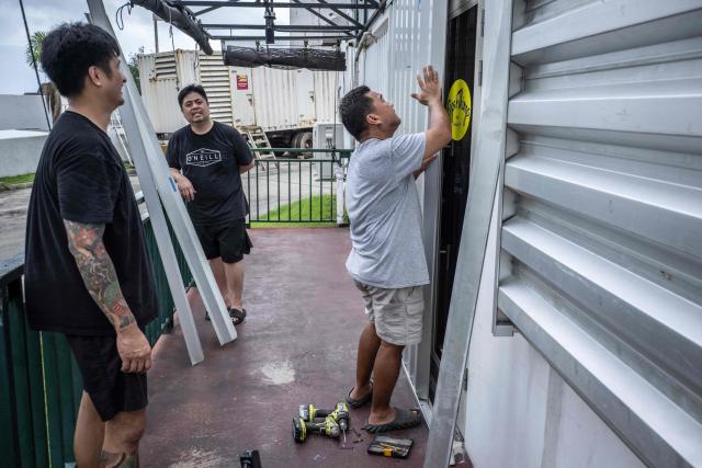 People install metal barricades on a restaurant as the forecasted Super Typhoon Bavi approaches in Guam, Northern Mariana Islands, on July 5, 2026. (Photo by Yuichi YAMAZAKI / AFP)