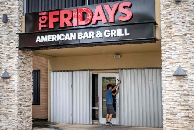 A man installs metal barricades on a restaurant as the forecasted Super Typhoon Bavi approaches in Guam, Northern Mariana Islands, on July 5, 2026. (Photo by Yuichi YAMAZAKI / AFP)