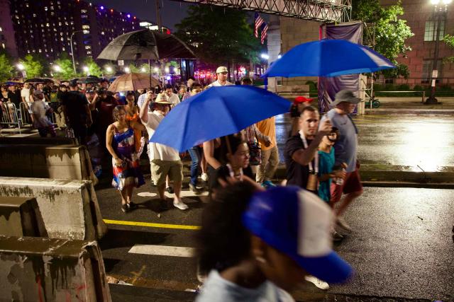 People re-enter the event site after being evacuated due to storms in the area during the "Salute to America" Independence Day celebration on the National Mall in Washington, DC, on July 4, 2026. The nation is marking the 250th anniversary of the United States Declaration of Indpendence. (Photo by Amid FARAHI / AFP)
