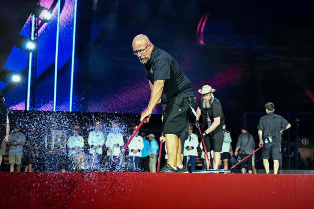 Workers push water off the stage before US President Donald Trump speaks during the "Salute to America" Independence Day celebration on the National Mall in Washington, DC, on July 4, 2026. The nation is marking the 250th anniversary of the United States Declaration of Indpendence. (Photo by Kent NISHIMURA / AFP)