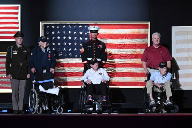 WWII veteran Harry F. Rose (L), US Marine Corps veteran Donald G. Graves (C) and retired US Army Captain Ken Schubring and his son (R) stand on stage as US President Donald Trump (unseen) speaks during the “Salute to America” Independence Day celebration on the National Mall in Washington, DC, on July 4, 2026.. The nation is marking the 250th anniversary of the United States Declaration of Indpendence. (Photo by Alex WROBLEWSKI / AFP)