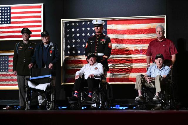 WWII veteran Harry F. Rose (L), US Marine Corps veteran Donald G. Graves (C) and retired US Army Captain Ken Schubring and his son (R) stand on stage as US President Donald Trump (unseen) speaks during the “Salute to America” Independence Day celebration on the National Mall in Washington, DC, on July 4, 2026.. The nation is marking the 250th anniversary of the United States Declaration of Indpendence. (Photo by Kent NISHIMURA / AFP)