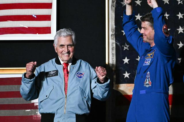 (L/R) Retired astronaut Harrison Schmitt and Artemis II crew member Reid Wiseman stand onstage as US President Donald Trump speaks during the "Salute to America" Independence Day celebration on the National Mall in Washington, DC, on July 4, 2026. The nation is marking the 250th anniversary of the United States Declaration of Indpendence. (Photo by Kent NISHIMURA / AFP)