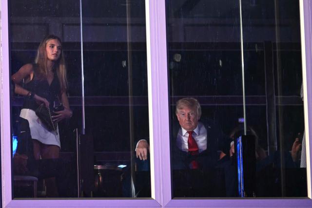 Kai Trump and =US President Donald Trump watch the fireworks display during the "Salute to America" Independence Day celebration on the National Mall in Washington, DC, in the early morning hours of July 5, 2026. The nation is marking the 250th anniversary of the United States Declaration of Indpendence. (Photo by Kent NISHIMURA / AFP)