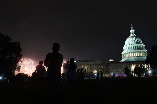 People watch fireworks during the "Salute to America" Independence Day celebration on the National Mall in Washington, DC, in the early morning hours of July 5, 2026. The nation is marking the 250th anniversary of the United States Declaration of Indpendence. (Photo by Matthew Hatcher / AFP)