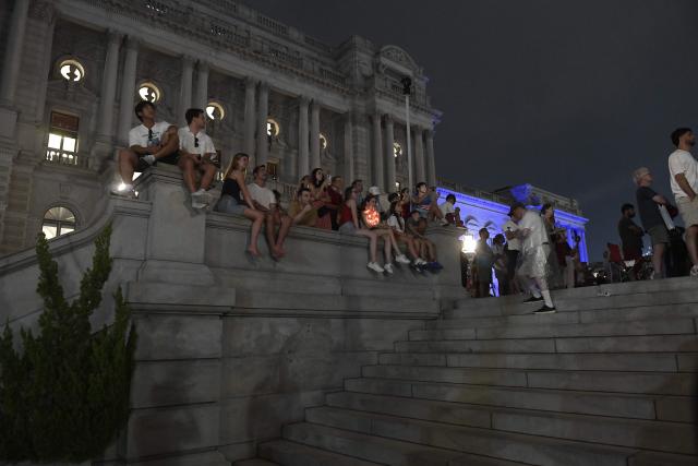 People watch fireworks during the "Salute to America" Independence Day celebration on the National Mall in Washington, DC, in the early morning hours of July 5, 2026. The nation is marking the 250th anniversary of the United States Declaration of Indpendence. (Photo by Matthew Hatcher / AFP)
