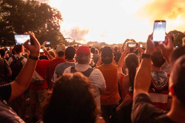 People watch fireworks during the "Salute to America" Independence Day celebration in Washington, DC, in the early morning hours of July 5, 2026. The nation is marking the 250th anniversary of the United States Declaration of Indpendence. (Photo by Ken Cedeno / AFP)