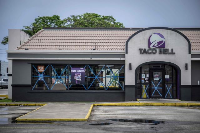 Windows at a Taco Bell restaurant are taped as the forecasted Super Typhoon Bavi approaches in Guam, Northern Mariana Islands, on July 5, 2026. People in Guam and the Northern Marianas moved to emergency evacuation centers and made last-minute preparations on July 5, hours before a "super typhoon" was projected to bulldoze through the US Pacific territories. (Photo by Yuichi YAMAZAKI / AFP)