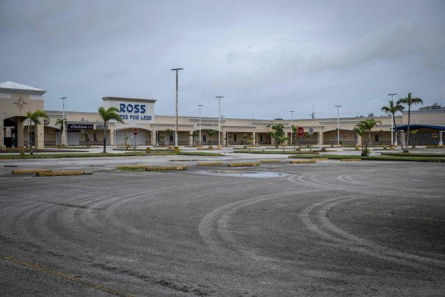 A empty parking lot is seen at a shopping center as the forecasted Super Typhoon Bavi approaches in Guam, Northern Mariana Islands, on July 5, 2026. People in Guam and the Northern Marianas moved to emergency evacuation centers and made last-minute preparations on July 5, hours before a "super typhoon" was projected to bulldoze through the US Pacific territories. (Photo by Yuichi YAMAZAKI / AFP)