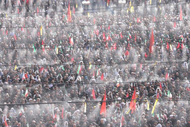 Mourners gather under the water-mist fans installed at the Grand Mosalla to pray for Iran's slain supreme leader Ayatollah Ali Khamenei during the second day of funeral ceremonies in Tehran on July 5, 2026. Prayers were held July 5 over the casket of Iran's late supreme leader Ali Khamenei, the second day of funeral ceremonies that have drawn huge crowds to pay their final respects in Tehran. Khamenei ruled the Islamic republic from 1989 until he was killed aged 86 in an airstrike on the first day of the US-Israeli war with Iran on February 28. (Photo by ATTA KENARE / AFP) / 