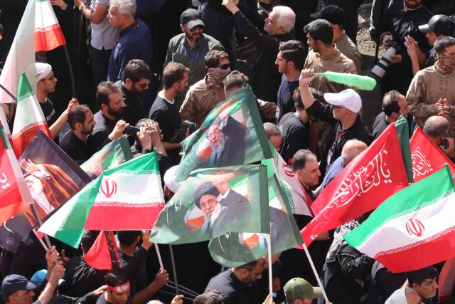 Mourners leave after gathering under the water-mist fans installed at the Grand Mosalla to pray for Iran's slain supreme leader Ayatollah Ali Khamenei during the second day of funeral ceremonies in Tehran on July 5, 2026. Prayers were held July 5 over the casket of Iran's late supreme leader Ali Khamenei, the second day of funeral ceremonies that have drawn huge crowds to pay their final respects in Tehran. Khamenei ruled the Islamic republic from 1989 until he was killed aged 86 in an airstrike on the first day of the US-Israeli war with Iran on February 28. (Photo by ATTA KENARE / AFP) / 