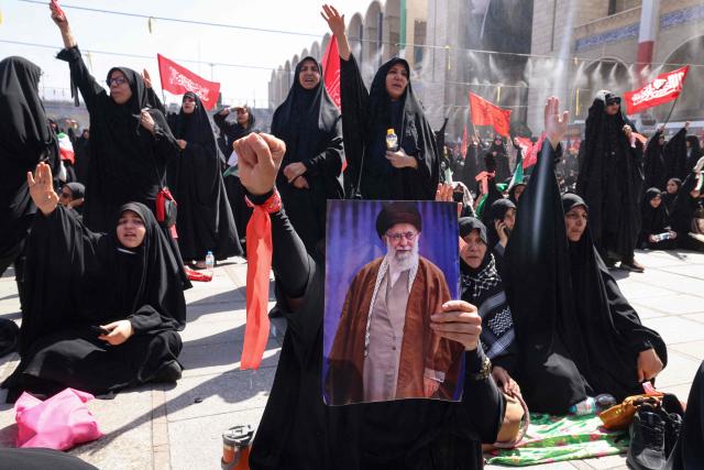 Mourners react as they pay their respects at the Grand Mosalla where they gathered to pray for Iran's slain supreme leader Ayatollah Ali Khamenei during the second day of funeral ceremonies in Tehran on July 5, 2026. Prayers were held July 5 over the casket of Iran's late supreme leader Ali Khamenei, the second day of funeral ceremonies that have drawn huge crowds to pay their final respects in Tehran. Khamenei ruled the Islamic republic from 1989 until he was killed aged 86 in an airstrike on the first day of the US-Israeli war with Iran on February 28. (Photo by ATTA KENARE / AFP) / 