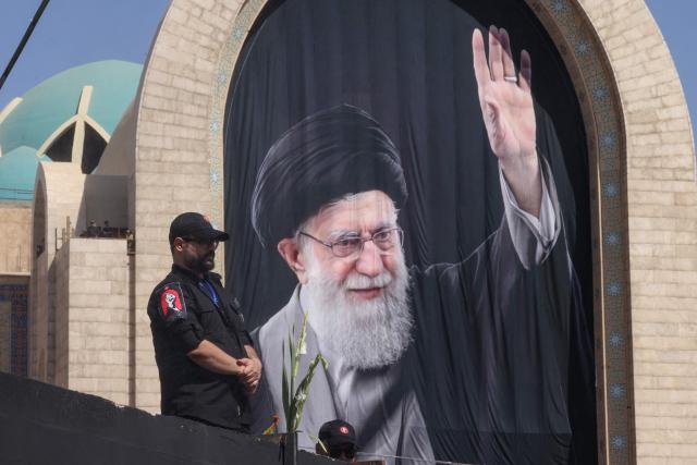 Security are seen as mourners gather to pray for Iran's slain supreme leader Ayatollah Ali Khamenei during the second day of funeral ceremonies at the Grand Mosalla in Tehran on July 5, 2026. Prayers were held July 5 over the casket of Iran's late supreme leader Ali Khamenei, the second day of funeral ceremonies that have drawn huge crowds to pay their final respects in Tehran. Khamenei ruled the Islamic republic from 1989 until he was killed aged 86 in an airstrike on the first day of the US-Israeli war with Iran on February 28. (Photo by ATTA KENARE / AFP) / 