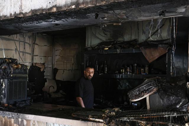 A Palestinian man inspects the aftermath at his restaurant after it was burned down by settlers during an attack in the western area of the Al-Lubban ash-Sharqiya village, south of Nablus, in the occupied West Bank on on July 5, 2026. Violence has escalated in the West Bank, which Israel has occupied since 1967, since the start of the Gaza war in October 2023. (Photo by JAAFAR ASHTIYEH / AFP)