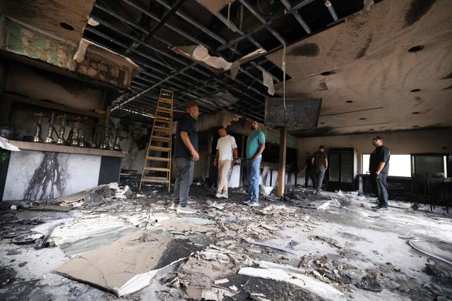 Palestinian men inspect the aftermath inside a restaurant after it was burned down by settlers during an attack in the western area of the Al-Lubban ash-Sharqiya village, south of Nablus, in the occupied West Bank on on July 5, 2026. Violence has escalated in the West Bank, which Israel has occupied since 1967, since the start of the Gaza war in October 2023. (Photo by JAAFAR ASHTIYEH / AFP)