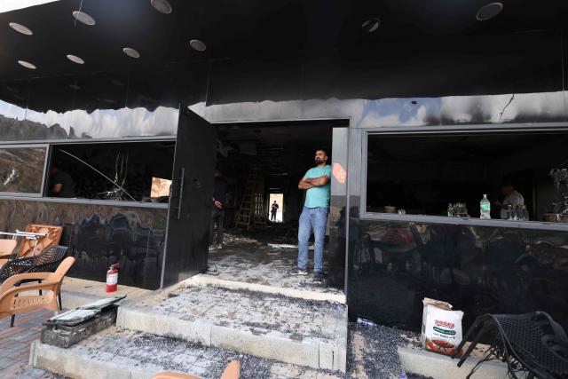 A Palestinian man inspects the aftermath at his restaurant after it was burned down by settlers during an attack in the western area of the Al-Lubban ash-Sharqiya village, south of Nablus, in the occupied West Bank on on July 5, 2026. Violence has escalated in the West Bank, which Israel has occupied since 1967, since the start of the Gaza war in October 2023. (Photo by JAAFAR ASHTIYEH / AFP)