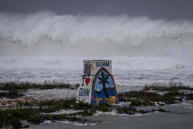 High waves crash against the coastline at a beach as the forecasted Super Typhoon Bavi approaches in Guam on July 5, 2026. People in Guam and the Northern Marianas moved to emergency evacuation centers and made last-minute preparations on July 5, hours before a "super typhoon" was projected to bulldoze through the US Pacific territories. (Photo by Yuichi YAMAZAKI / AFP)