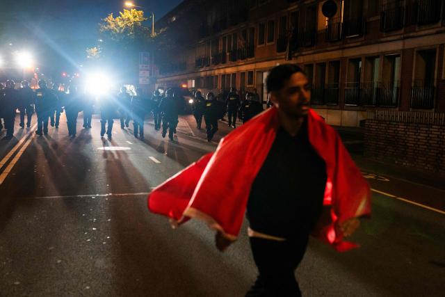 A Morocco supporter walks away from the Dutch police as they move in to clear the streets of Schilderswijk district, in The Hague on July 4, 2026, as Morocco supporters celebrate their team victory in the 2026 World Cup round of 16 football match between Canada and Morocco.  (Photo by Lina Selg / AFP)