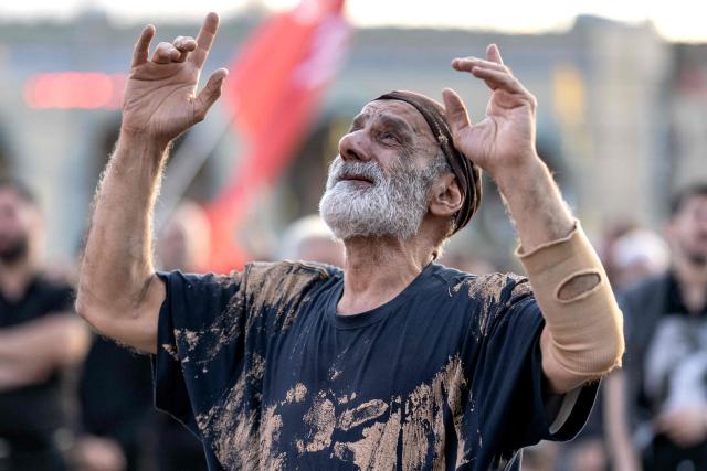 A man with mud smeared across his clothes in mourning reacts as people gather for the funeral ceremonies of Iran's slain supreme leader Ayatollah Ali Khamenei at the Grand Mosalla in Tehran on July 5, 2026. Iranian leaders on July 5 joined prayers over the casket of late supreme leader Ali Khamenei during a second day of funeral ceremonies, which was declared a public holiday across Iran. Khamenei's body will be moved out of the Grand Mosalla later in the day, where it is lying in state, as part of preparations for processions through the capital the following day. (Photo by AFP) / 