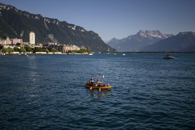 Tourists paddle in a canoe on the Lake Geneva off Montreux, western Switzerland, on July 4, 2026. (Photo by Fabrice COFFRINI / AFP)
