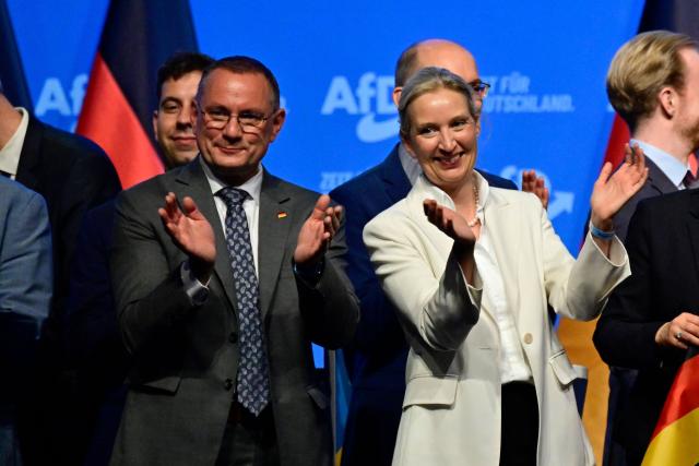 AfD co-leaders Alice Weidel (R) and Tino Chrupalla applaud after singing the national anthem at the end of the party congress of far-right Alternative for Germany (AfD) at the Messe Erfurt fairground in Erfurt, eastern Germany on July 5, 2026.  (Photo by John MACDOUGALL / AFP)