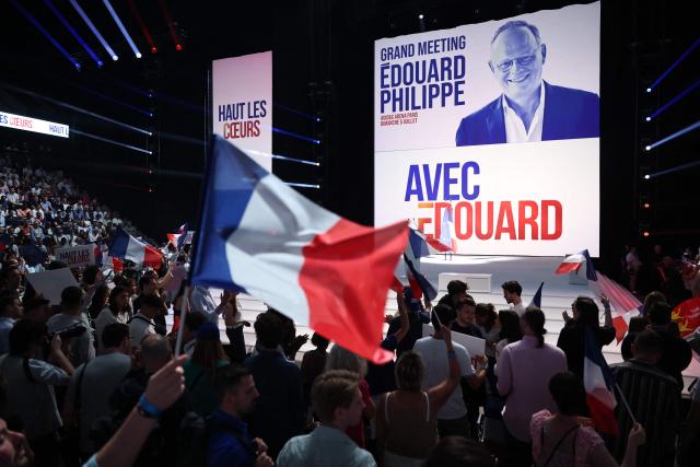 Supporters wave French flags during a presidential election campaign rally of French right-wing party Horizons founder and president, mayor of Le Havre and candidate for the 2027 French presidential election Edouard Philippe at the Adidas Arena, in northern Paris on July 5, 2026. (Photo by SIMON WOHLFAHRT / AFP)
