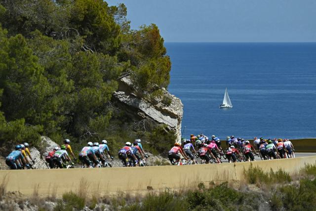 The pack of riders (peloton) cycles along the Mediterranean coastline near Sitges during the 2nd stage of the 113th edition of the Tour de France cycling race, 168,5 km between Tarragona and Barcelona in northeastern Spain, on July 5, 2026. (Photo by Loic VENANCE / AFP)