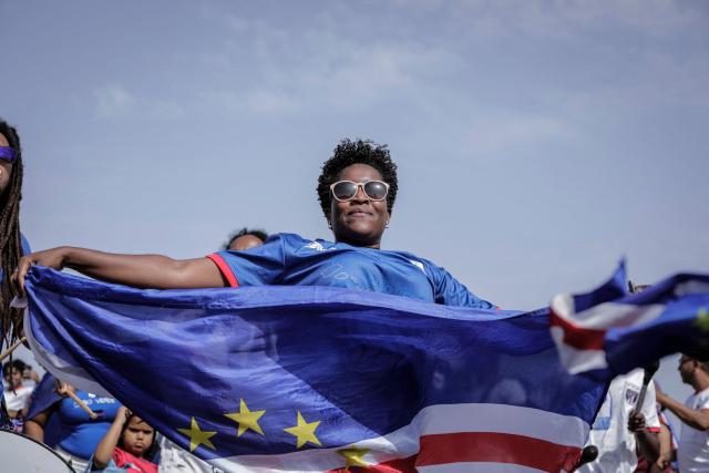 A Cape Verde supporter waves the national flag during celebrations in Praia on July 5, 2026, as the national football team returns home following its participation in the 2026 FIFA World Cup. (Photo by Jose Correia / AFP)