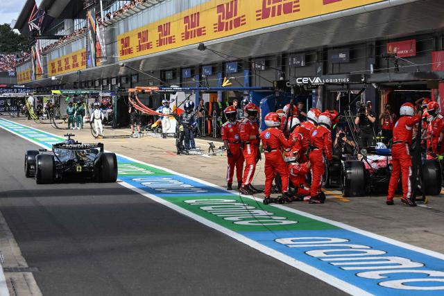 Mercedes' British driver George Russell (L) overtakes Ferrari's British driver Lewis Hamilton (R) in pit lane during the Formula One British Grand Prix at the Silverstone motor racing circuit in Silverstone, central England, on July 5, 2026. (Photo by PETER POWELL / POOL / AFP)